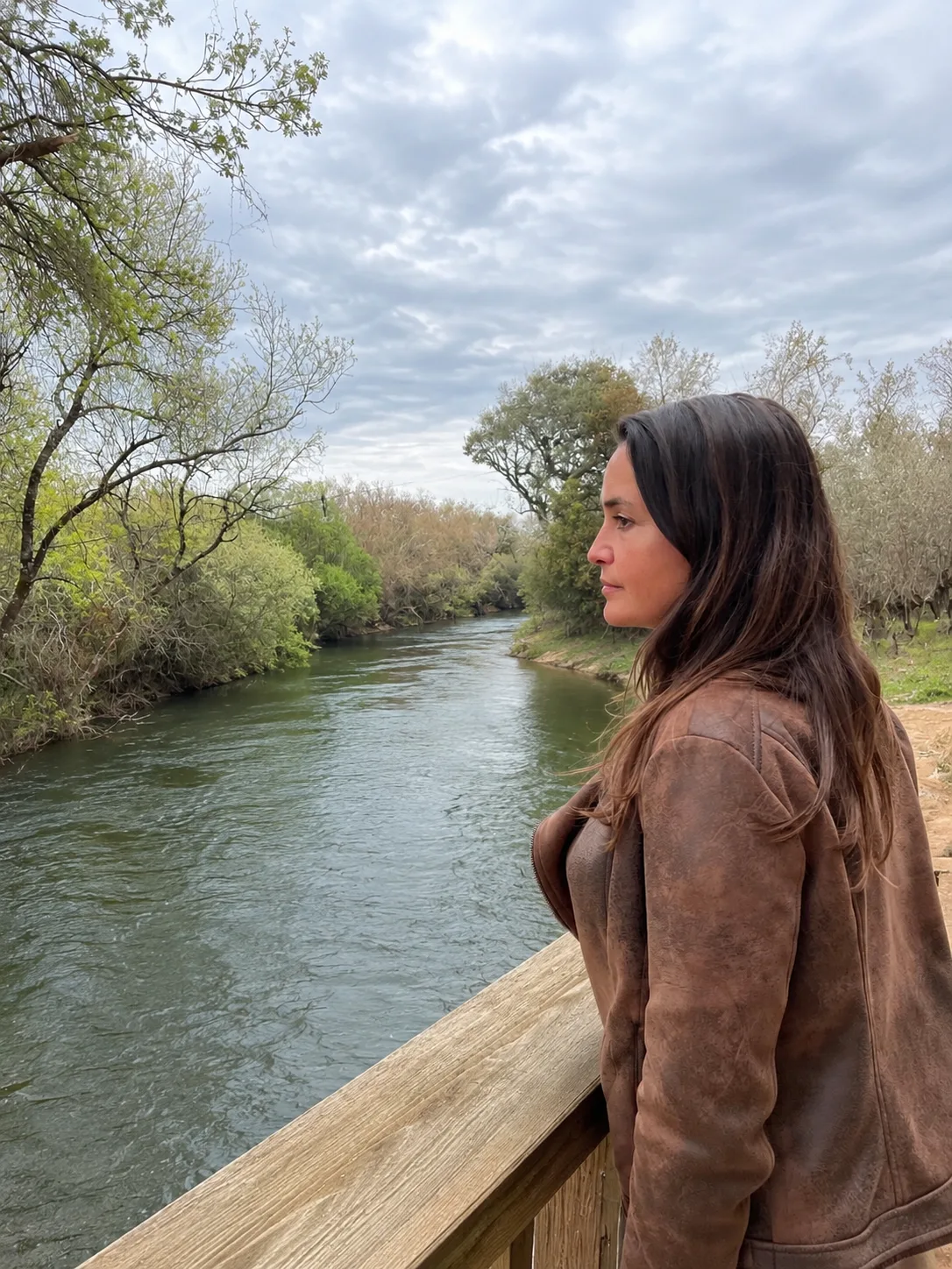 Daniela Velho de perfil, junto ao rio, a olhar a paisagem
